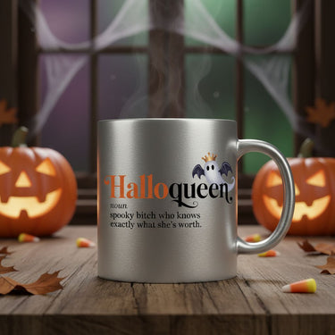 The 👑 HalloQueen Silver Mug – Halloween Mug for the Spooky Baddie sits on a wooden table with